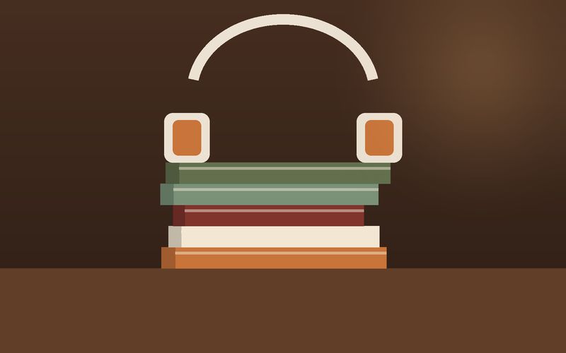 سمّاعتان فوق كتبٍ مكدّسة