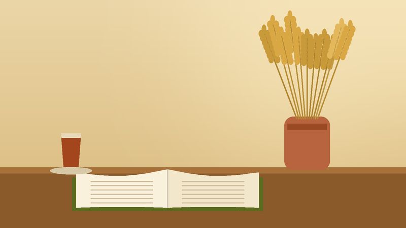 سنبلات قمحٍ في جرّة بجانب كتابٍ مفتوح